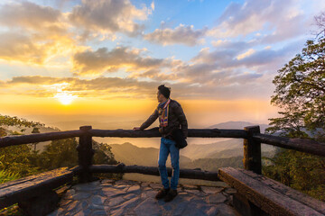 Fototapeta premium the man standing alone and watching sunrise on a fence