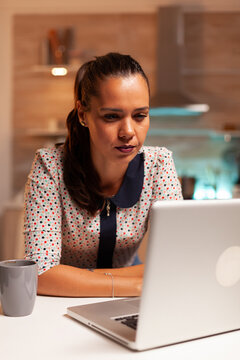 Businesswoman squiting eyes because of exhaustion while working on a project late at night from home. Employee using modern technology at midnight doing overtime for job, business, career, network