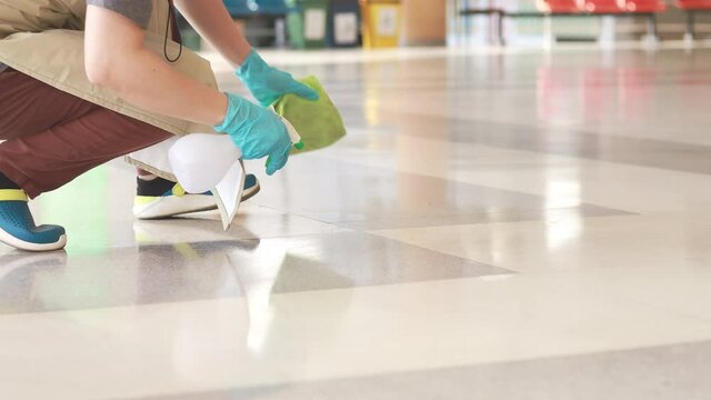 Cleaning staff wipe the floor, janitor or cleaning worker uses a germicidal spray and mops with a clean cloth on the floor, Hygiene care, Cleaning a building, Prevent the spread of germs.