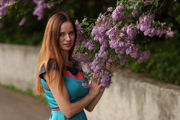 portrait of a woman against the background of lilac bushes