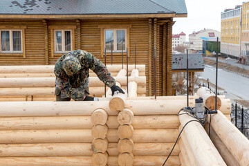 Carpenter at the construction of wooden house