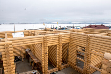 Construction of wooden house against the winter landscape