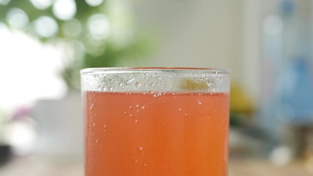 A Glass with Cold, Sweet, Acidulated, and Refreshing Oranges Drink. Shooting with a Glass with Tasty Fresh Drink.