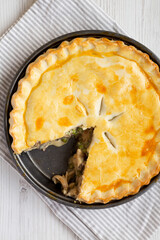 A Piece of Chicken Pot Pie on a white wooden background, top view. Flat lay, overhead, from above. Close-up.