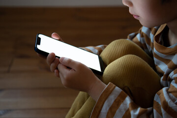 一人でスマートフォンを利用する子供