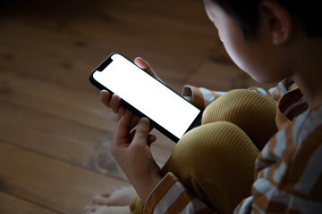 一人でスマートフォンを利用する子供
