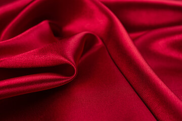Red silk fabric. Beautiful abstract background made of folds of shiny satin.