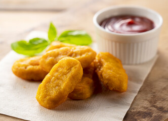 Chicken nuggets and ketchup on a wooden background