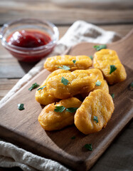 Chicken nuggets and ketchup on a wooden background