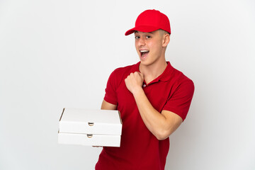 Pizza delivery man with work uniform picking up pizza boxes isolated on white background celebrating a victory