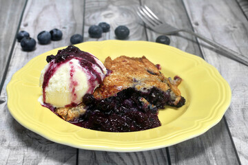 Blueberry cobbler with a scoop of vanilla ice cream, close up.