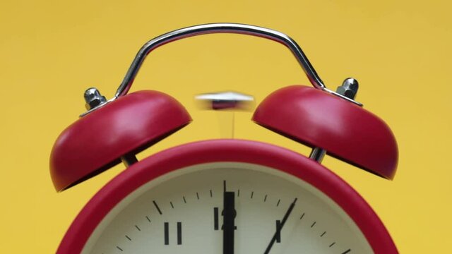 Close up red alarm clock on yellow background