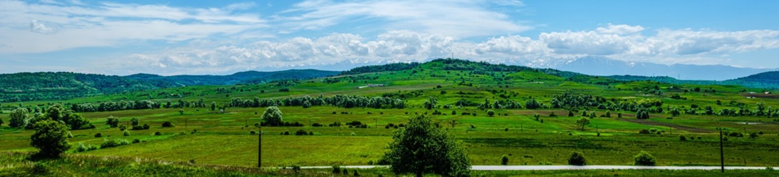 the road at the foot of the hill with mountains behind