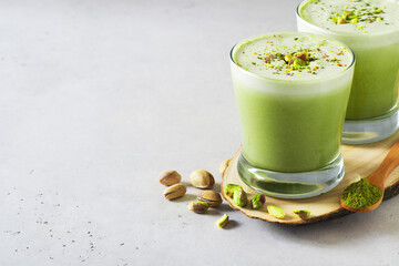 Green matcha latte with pistachios and matcha powder - obrazy, fototapety, plakaty