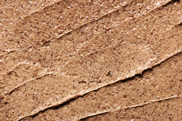 The texture of a brown body scrub made from ground coffee beans. Organic cleanser made from natural ingredients. A mild, sugar-textured exfoliating peeling. Spa treatments with skincare