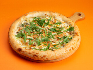 Pizza with cheese and arugula on a yellow background.