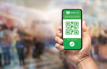 hand using mobile phone show international certificate health passport, vaccinated at airport for travel during covid-19 pandemic.