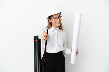 Young architect woman with helmet and holding blueprints isolated on white background pointing front with happy expression