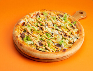 Pizza with salad and cheese sauce. On a yellow background.