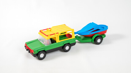 Fototapeta premium Plastic toy multicolored cars isolated on white background. SUV with a trailer.