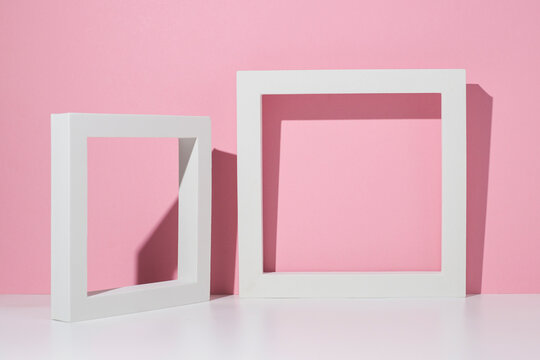 Two white square podiums for presentation on a white pink background