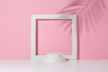 Podium white square, circles for presentation under the shadow of palm leaves on a white pink background