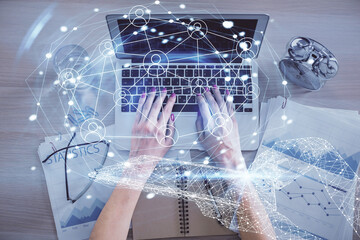 Double exposure of woman hands working on computer and social network theme hologram drawing. Top View. People connection concept.