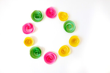 A circle of multi-colored paper homemade flowers, similar to roses. Isolated. Copy space.