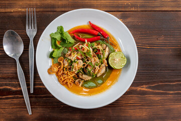 Fresh oysters are served in a white plate and topped with a spicy Thai-style sauce, also known as 