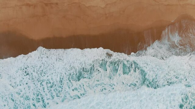 amazing seascape with wide ocean foamy waves rolling on empty sand beach one after another slow motion upper view
