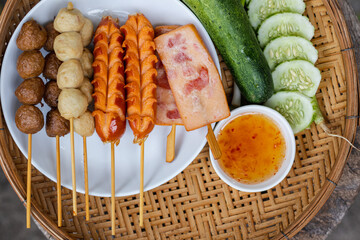Skewers are arranged inside a white plate to prepare for the party. Fried food such as meatballs and hot dogs are skewed to make it easy to eat on a walk-in size, street food concept.