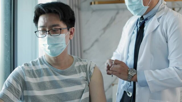 Vaccination, immunization, disease prevention concept. people in medical face mask getting Covid-19 or flu vaccine at the hospital. Professional nurse or doctor giving antiviral injection to patient.