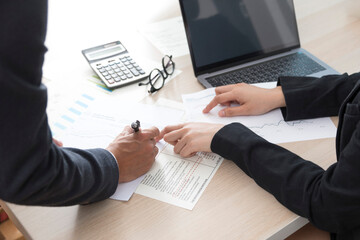 Business man and business woman working at office. Close up of business people discussing business plan.