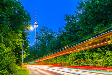 Germany, Stuttgart city skyline of television tower building behind illuminated streets with traffic by night