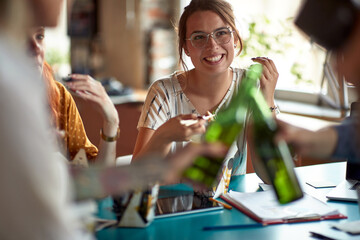A young woman enjoying lunch with her colleagues during a break in the office. Employees, office, work