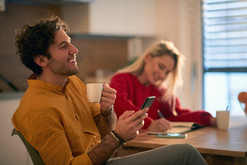 young couple having fun in the morning, drinking coffee, making plans for current day