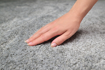 Woman touching grey carpet, close up. Close up of hand touching soft carpet. Gentle and fluffy...
