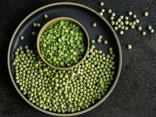 Cooking with green peas on black plates.