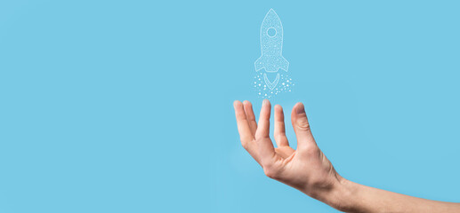 Male hand holding digital transparent rocket icon.Startup business concept. Rocket is launching and soar flying.Concept of business idea.