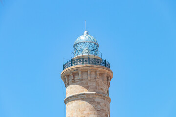 Fototapeta na wymiar Detail of the upper part with the glass dome of the Chipiona Lighthouse