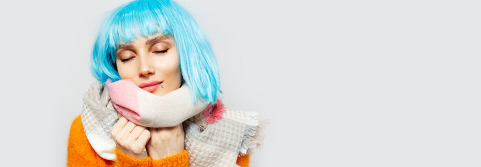 Portrait of pretty girl with blue hair wearing scarf on white background. Panoramic banner with copy space.