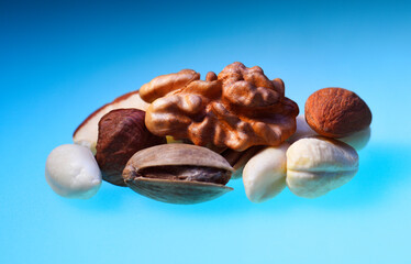 walnuts, cashews, almonds, pistachios, on a blue background. Isolated