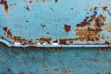 Perforated rusted metal surface with cracked blue peeling and painting.