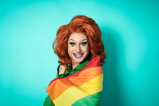Happy drag queen celebrating gay pride holding rainbow flag - LGBTQ social movement concept