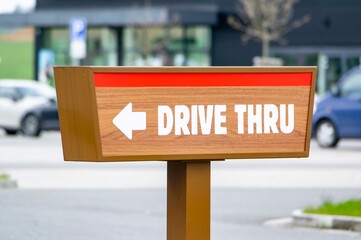 Drive Thru sign near a fast food restaurant showind the direction for cars