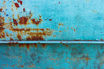 Perforated rusted metal surface with cracked blue peeling and painting.