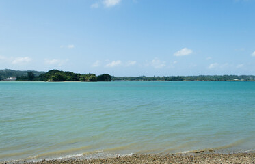 対岸に島のあるエメラルドグリーンの海岸