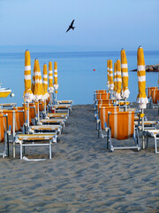 Typical Italian lido. Sand raked up, sunbeds folded and put near the closed umbrellas, pedal boats anchored to the shore: everything is ready for the next morning.
