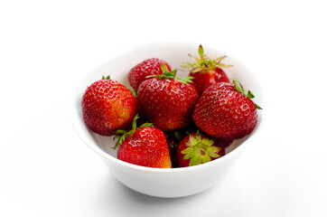 Ripe red strawberries in a white plate. Dessert. On white background.
