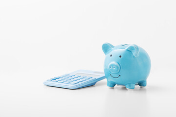 Blue piggy bank with calculator on white background